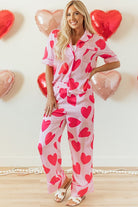 YNIQUE heart print valentine pajamas set with pink fabric and red hearts worn by smiling woman