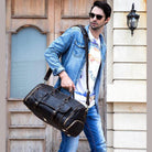Stylish man carrying a hot leather carry-on bag for travel with casual outfit