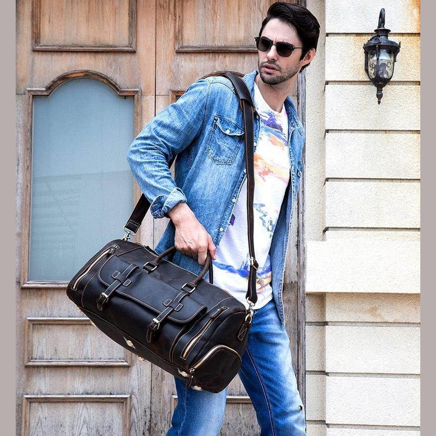 Stylish man carrying a hot leather carry-on bag for travel with casual outfit