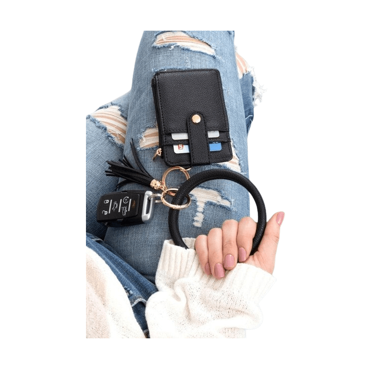 Aili's Corner ID holder keychain bracelet with a black wallet and car keys, styled with distressed jeans