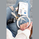 Elegant ID holder keychain bracelet in marble design, holding cards and a key fob on stylish denim.