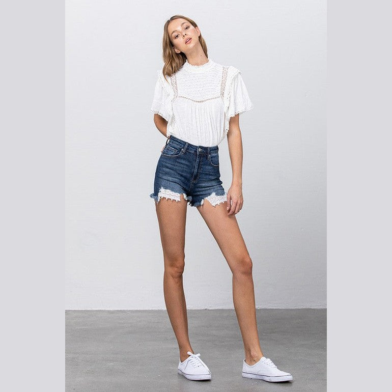 Insane Gene lace lining denim shorts in blue with frayed hem and paired with a white blouse