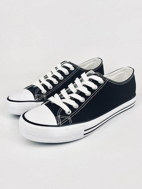 Classic black lace up flat sneakers with white accents for everyday casual wear