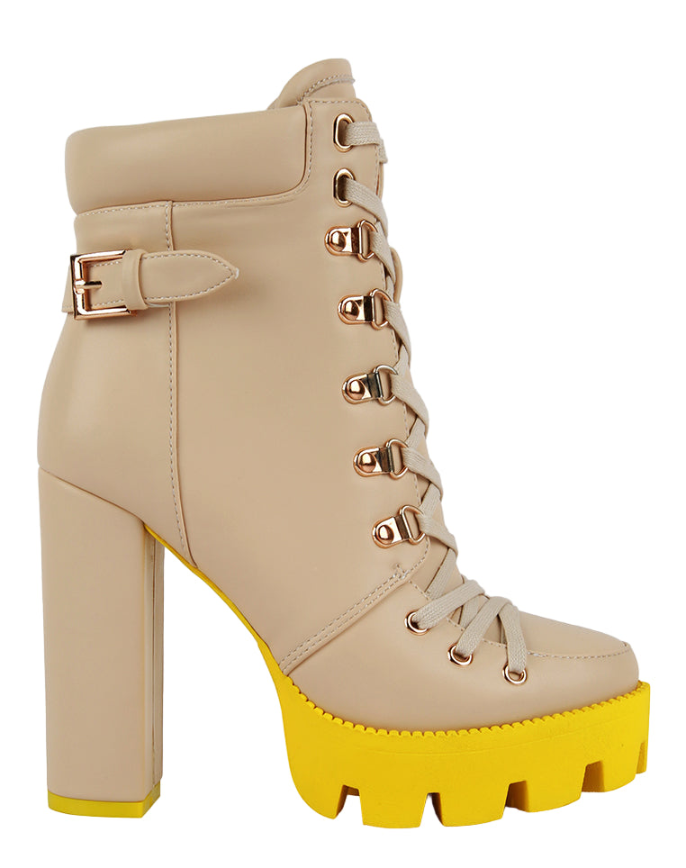 Beige platform boots with yellow soles on a white background