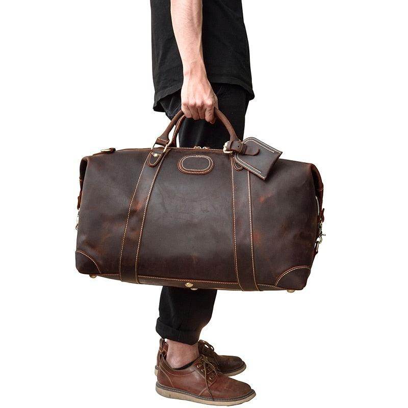 Large leather weekend bag being held by a person, perfect for travel and stylish outings
