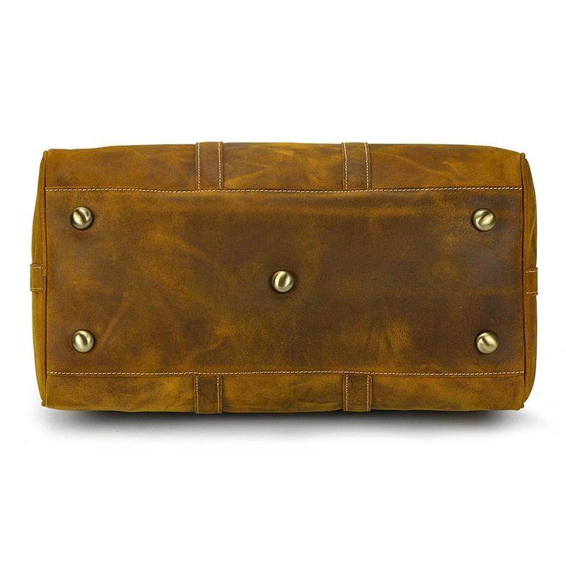 Bottom view of a large leather weekend bag with metal feet for stability and durability