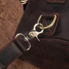 Close-up of durable leather strap and metal clip on a large travel bag for men by VacationGrabs