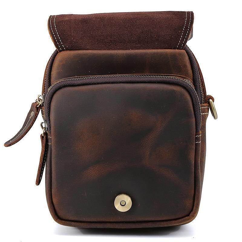 Brown leather messenger bag with a fold-over flap and zippered pockets for practical use