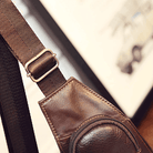 Detail of a leather sling bag for travel showcasing the adjustable strap and pocket design