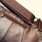 Close-up of a stylish leather sling bag for travel featuring a durable strap and zippered pocket