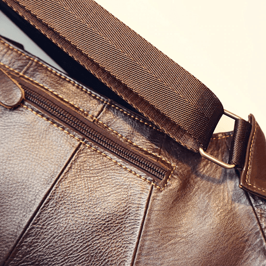 Close-up of a stylish leather sling bag for travel featuring a durable strap and zippered pocket