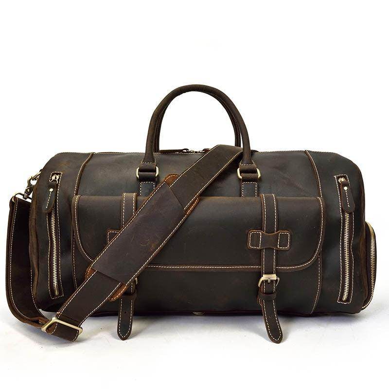 Durable leather weekend bag with shoulder strap, featuring dual handles and multiple compartments for organization