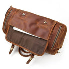 Leather weekend bag with shoulder strap featuring a spacious interior and multiple zippered pockets