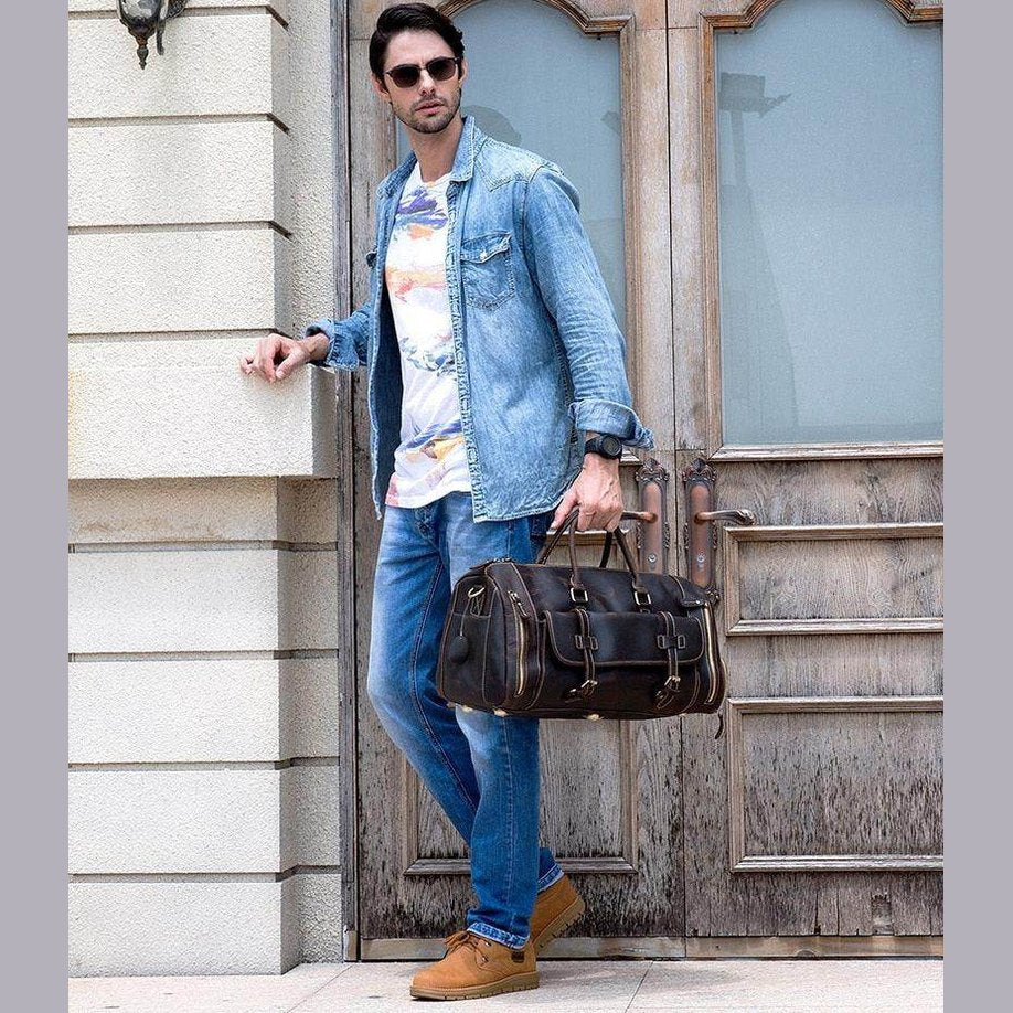 Stylish man carrying a leather weekend bag with shoulder strap, perfect for travel and casual outings