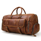 Brown leather weekend bag with shoulder strap featuring multiple pockets and sturdy handles