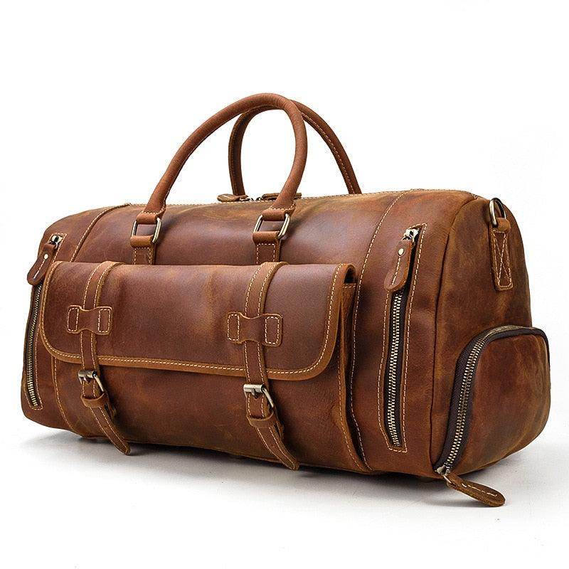 Brown leather weekend bag with shoulder strap featuring multiple pockets and sturdy handles