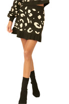 VacationGrabs leopard print mini skirt in black with cream spots worn with matching top and black ankle boots
