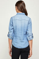 Back view of Blue Age lightweight denim shirt for travel worn by woman with rolled-up sleeves
