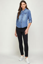 Blue Age lightweight denim shirt for travel worn by woman with black pants and white sneakers