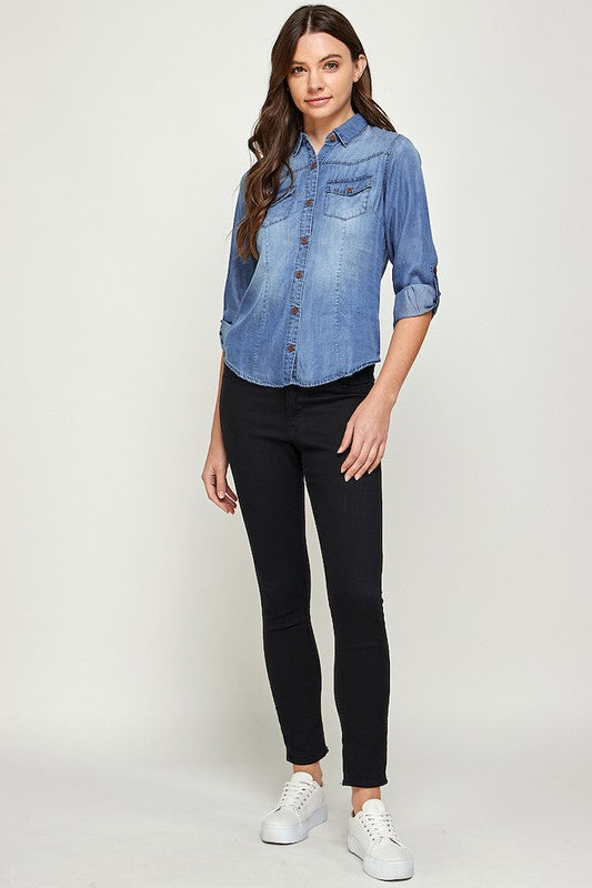 Blue Age lightweight denim shirt for travel worn by woman with black pants and white sneakers