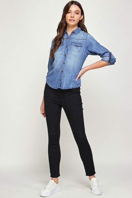 Blue Age lightweight denim shirt for travel worn by woman with rolled sleeves and black pants