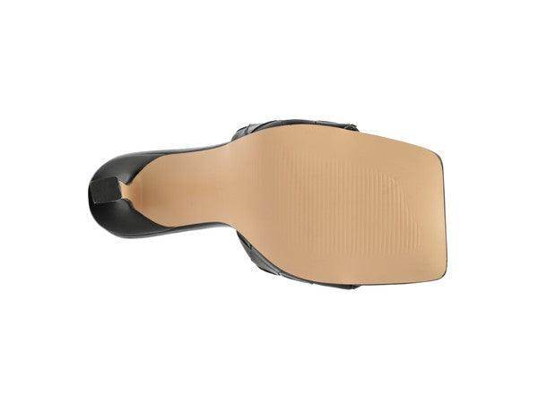 Sleek black women's heels with a smooth sole, perfect for pairing with stylish woven sandals