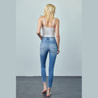 Back view of woman wearing trendy skinny jeans for travel in light blue denim