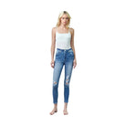 Insane Gene trendy skinny jeans for travel in distressed blue denim worn by model with white tank top