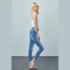 Woman wearing Insane Gene trendy skinny jeans for travel in light blue distressed denim