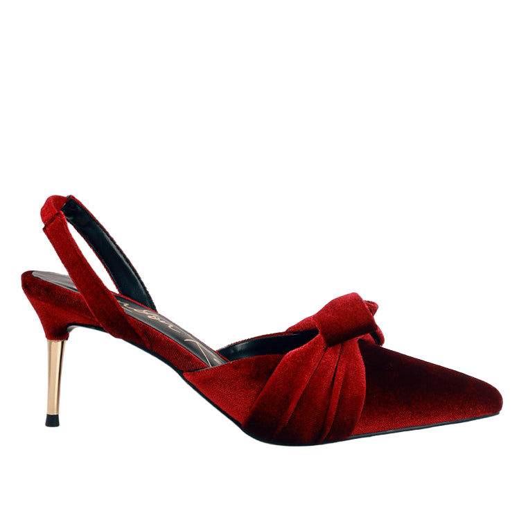 Red velvet high-heeled shoe with a bow on a white background