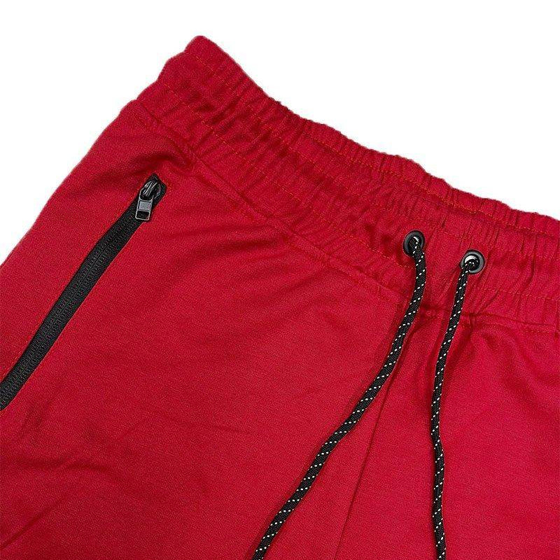 Close-up of mens red cotton shorts with elastic waistband and functional pockets by VacationGrabs