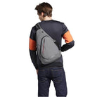 Man wearing a gray USB charging crossbody backpack for stylish and convenient travel.