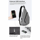Gray USB charging crossbody backpack with external USB interface for convenient mobile device charging