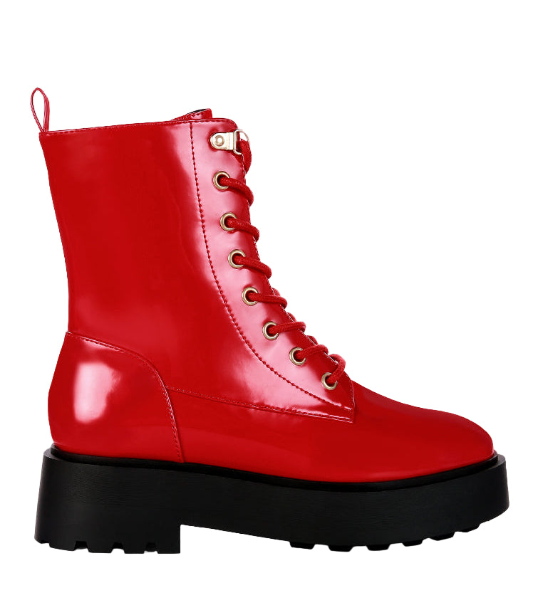 Red combat boot with a black sole on a light gray background