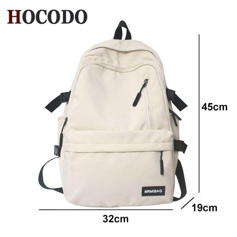Cream nylon backpack for travel featuring multiple pockets and adjustable straps for convenience