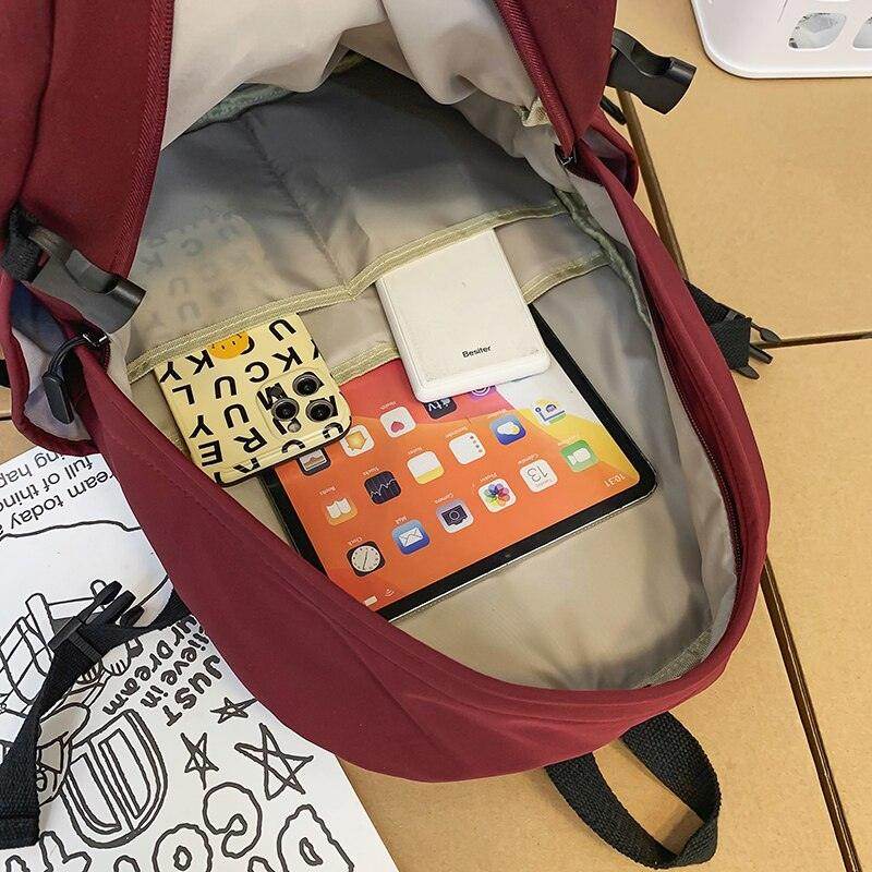 Interior view of a nylon backpack for travel featuring an iPad and accessories organized for easy access