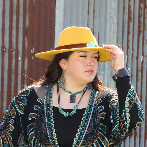 Model wearing a natural turquoise leather cord necklace with colorful bohemian clothing and hat