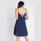 Back view of a navy blue flowy dress from Ivory Felix with spaghetti straps and a stylish cross-back design