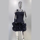 Black nightclub bandage dress for women with ruffled skirt and floral details on a silver mannequin