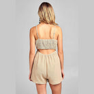Back view of a Women's one-piece romper with open back in beige by Ivory Felix