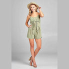 Ivory Felix Women's one-piece romper with open back in green, styled with a sun hat and sandals