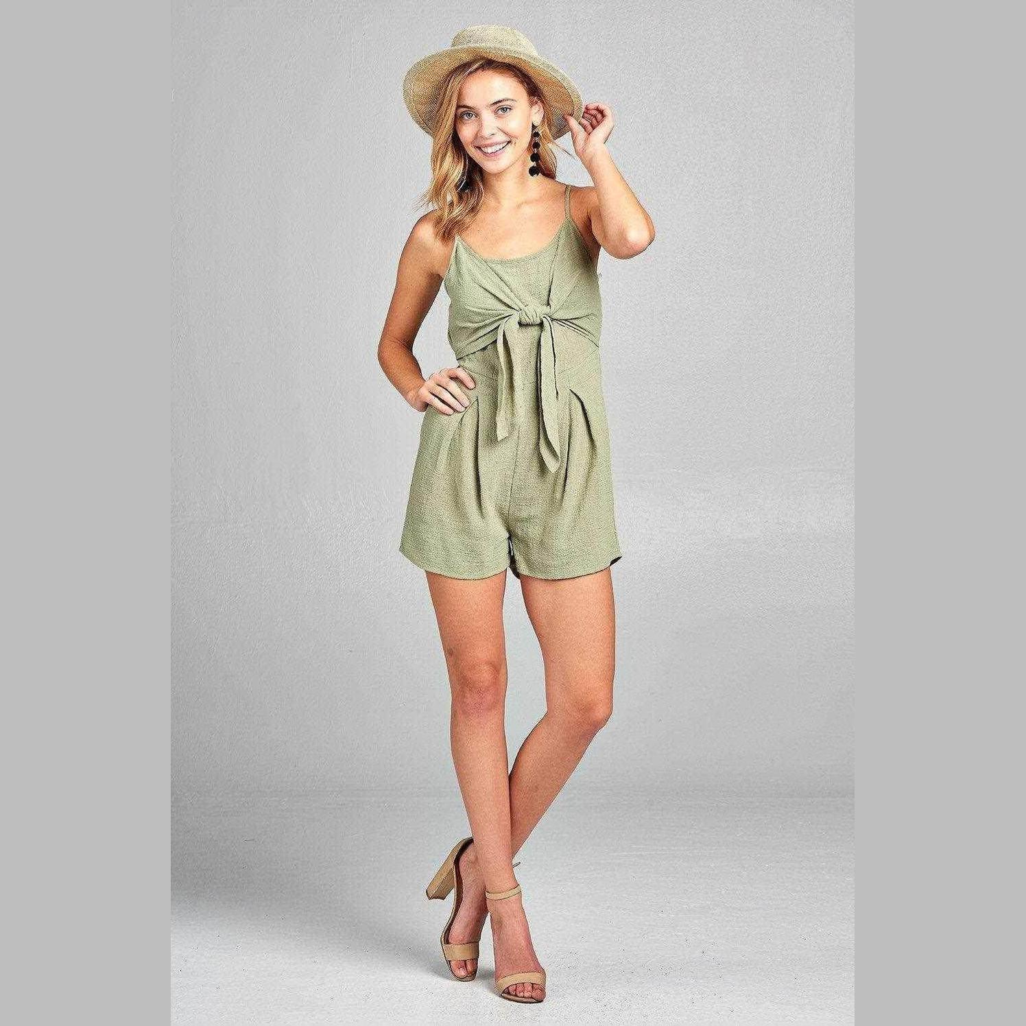 Ivory Felix Women's one-piece romper with open back in green, styled with a sun hat and sandals