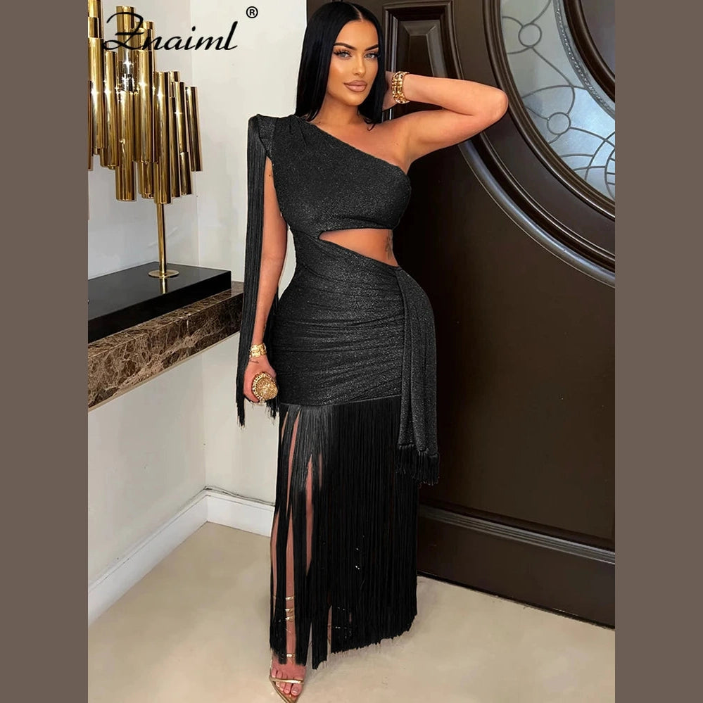 Woman wearing a stylish black one shoulder fringe dress with cutout detail and long fringe accents