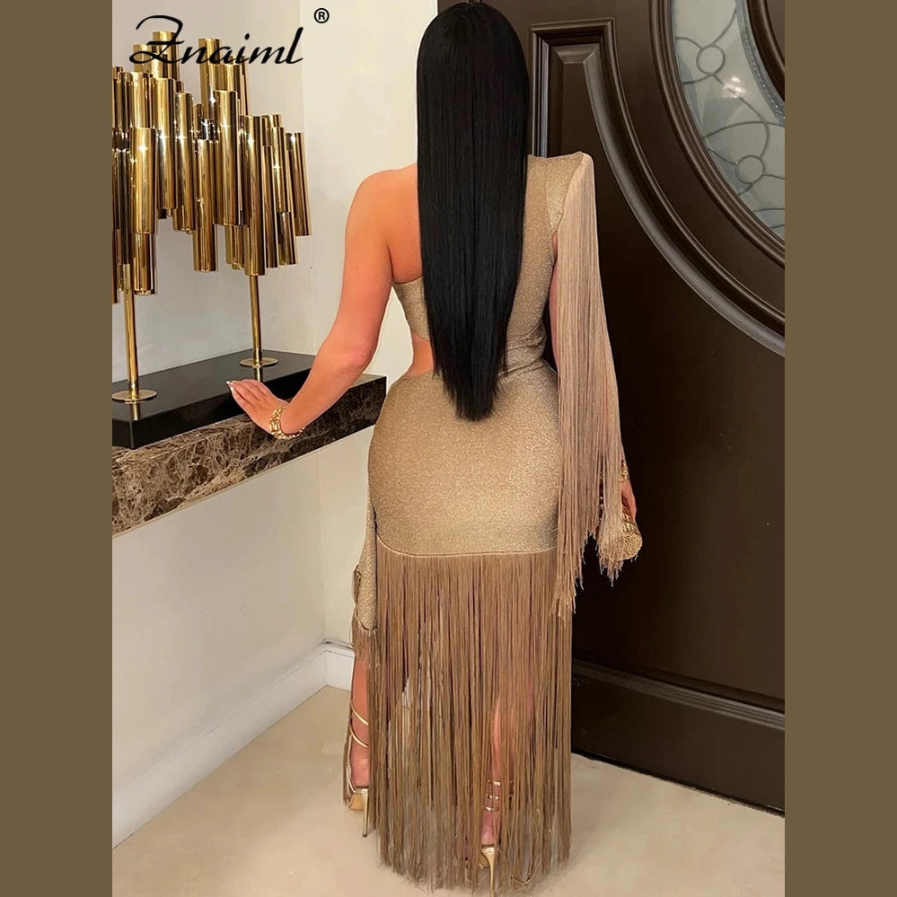 VacationGrabs one shoulder fringe dress in gold shimmer with long fringe details worn by model indoors