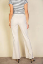 VacationGrabs women's pink flare trousers for women styled with a striped top and high heels from the back