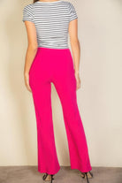 Back view of woman wearing pink flare trousers for women paired with striped short sleeve top
