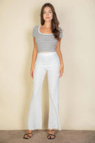 VacationGrabs women's white flare trousers modeled with black striped top and black sandals