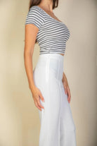Woman wearing white pants and striped crop top without pink flare trousers for women