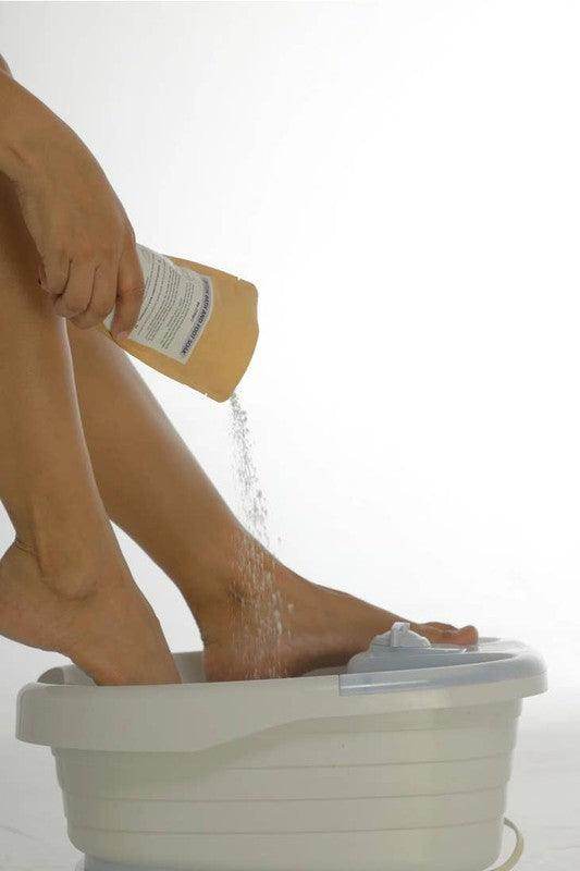 BeNat relaxing foot soak for colds being poured into a foot spa with a person's feet submerged