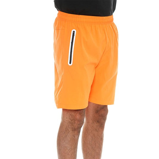 WEIV men's bright orange running shorts with zip pocket worn with white sneakers